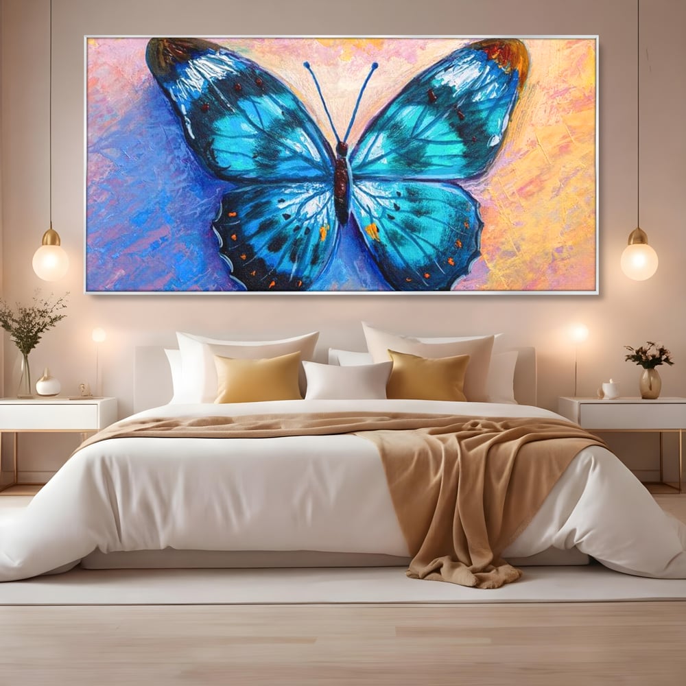 Tablou canvas cu tablou canvas cu fluture albastru, in rama de aluminiu argintiu, pe perete intr-un dormitor